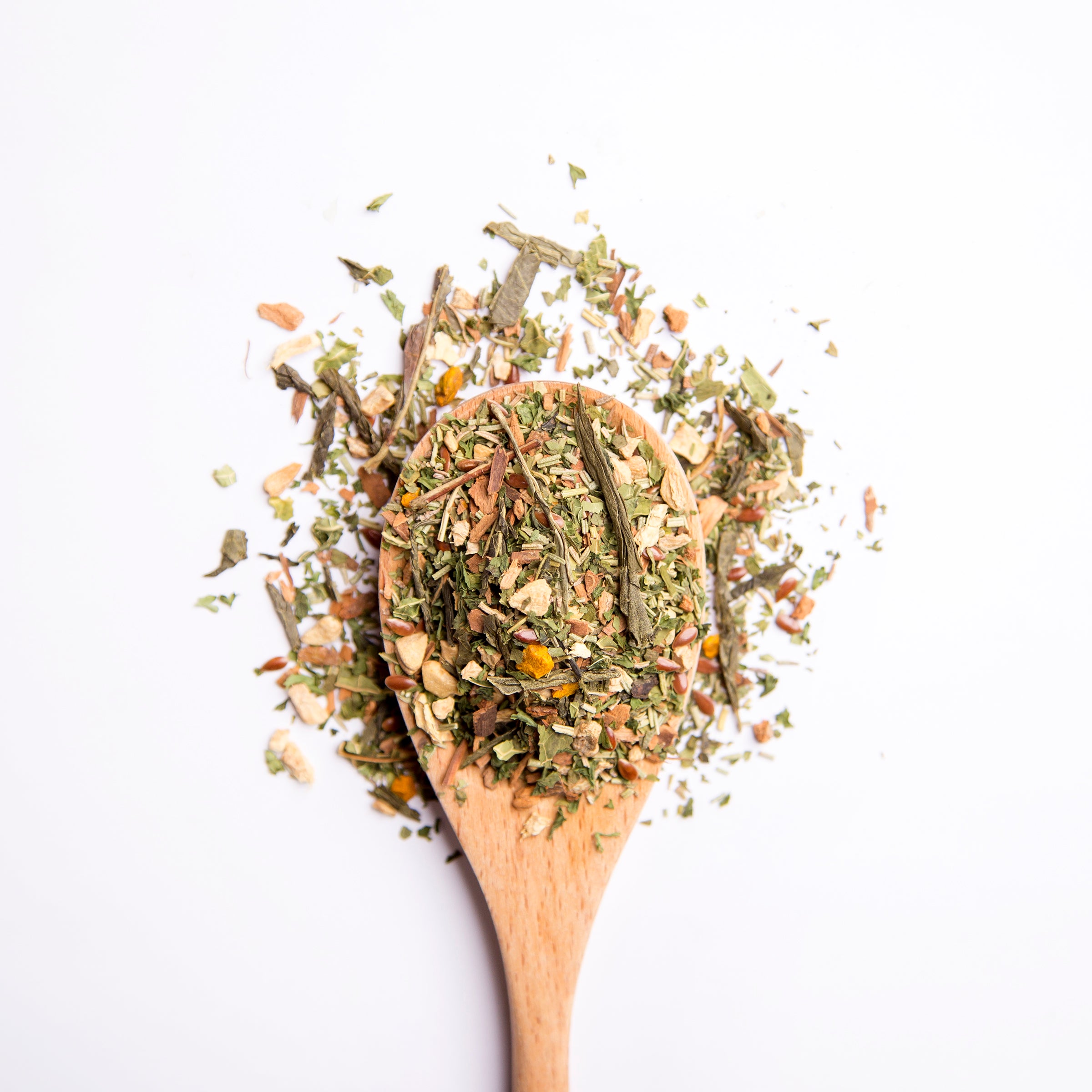 Organic herbal Herbal Focus tea blend with rosemary leaf, ginger, cinnamon, parsley and sencha green tea on wooden spoon