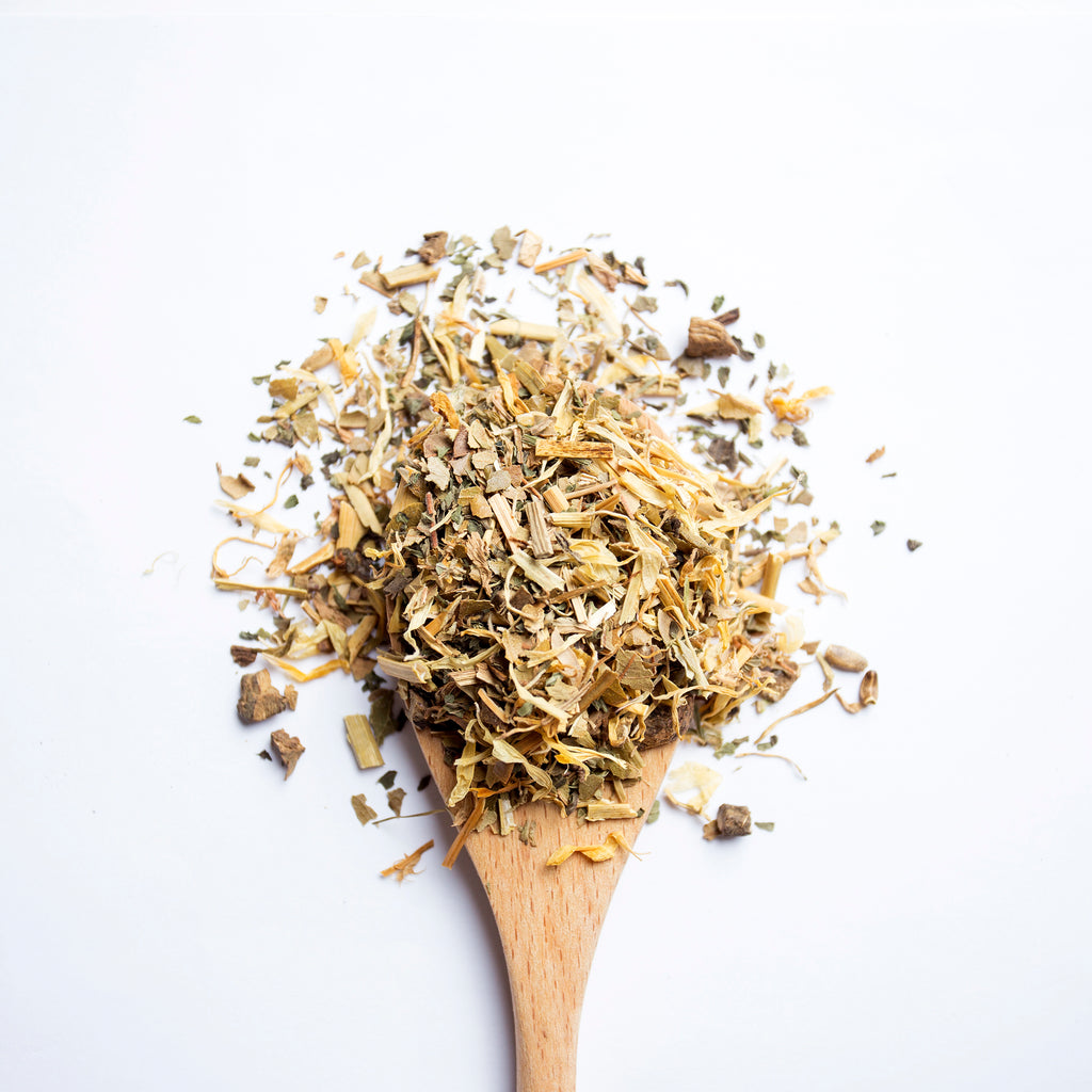 Organic herbal Complexion Beauty tea blend with roots and herbs on wooden spoon