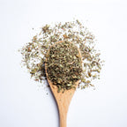 Organic herbal Relax & Unwind tea blend with lemon balm, ashwagandha, peppermint and ginger on wooden spoon