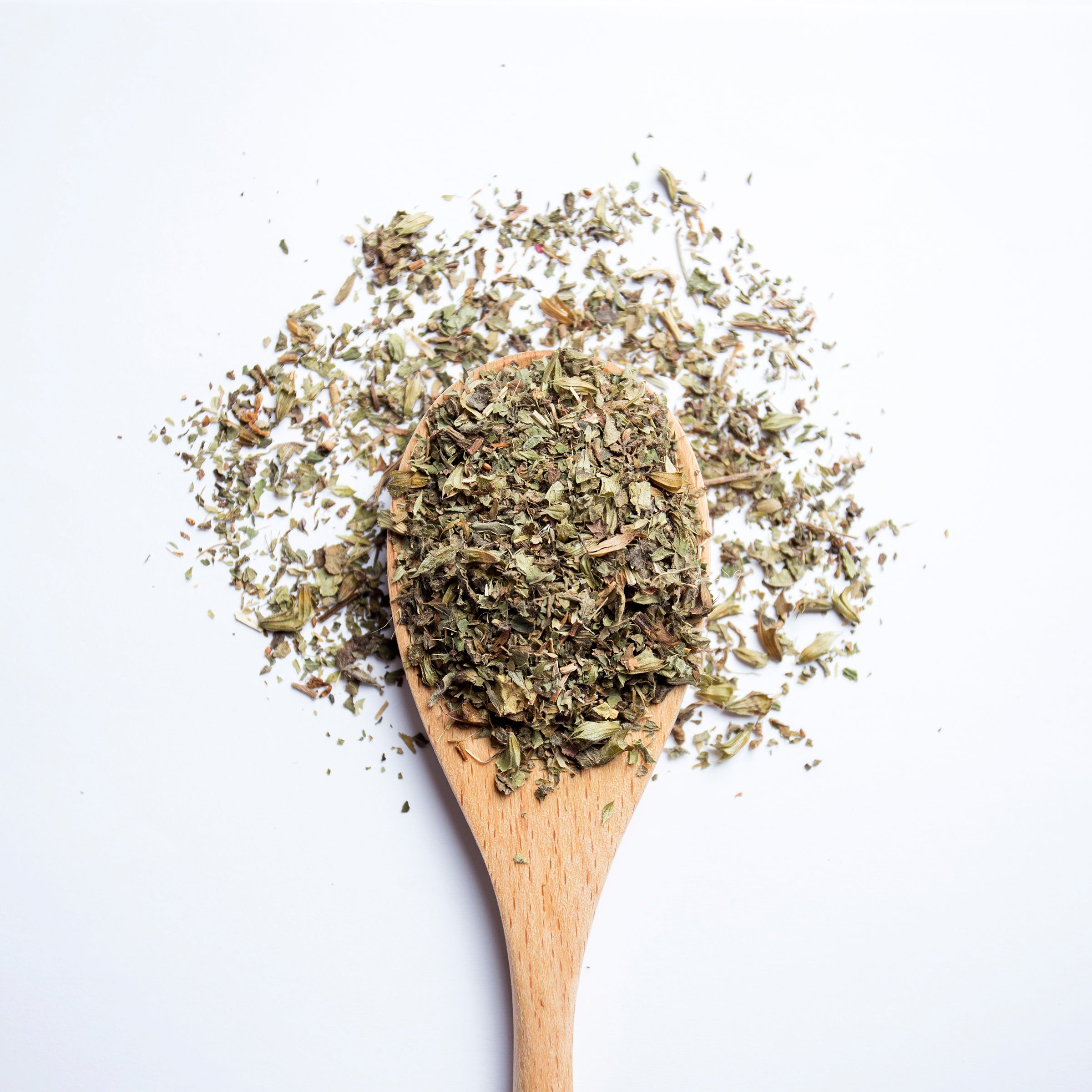 Organic herbal Relax & Unwind tea blend with lemon balm, ashwagandha, peppermint and ginger on wooden spoon